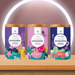 A trio of the Ben & Anna bath salts on a wooden table including a lavender rose and cornflower fragrance. 