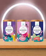 A trio of the Ben & Anna bath salts on a wooden table including a lavender rose and cornflower fragrance. 