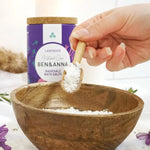 Ben & Anna lavender bath salts in a scooper being poured into a wooden bowl