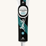 Ben & Anna certified 100% natural activated charcoal toothpaste showing a black, green and blue stripe design on the tube with a playful smile slogan in white in the middle.