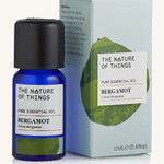 Bergamot pure essential oil in a blue glass bottle in front of a decorative blue cardboard box.