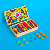 Billes & Co kids recycled glass Memphis marble set open on a blue background with some coloured marbles scattered in front of the box