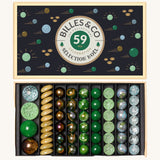 Billes & Co Christmas Selection Glass Marbles Set box, with various green, yellow and frosted marbles inside their box, on a cream background