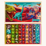 The Billes & Co large collectible glass marbles box, with a dinosaur theme. The box is open to show the different types and colours of glass marbles, next to the lid that is illustrated with colourful dinosaurs.