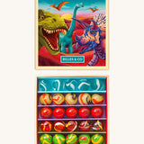 The opened Billes & Co collectible glass marbles minibox with a dinosaur theme showcasing the different coloured marbles inside, next to the colourful illustrated box.