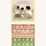 Billes & Co marbles and Babyatoutprix collaboration set. Features 30 pastel coloured glass marbles including green pink and white with a mix of textured marbles. Comes in a artistic  box showing 3 people playing marbles on a field with a castle in the background.