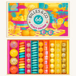Billes & Co Juicy Colours Glass Marbles in various colours of blue, pink, yellow and frosted glass marbles inside their box, on a cream back ground