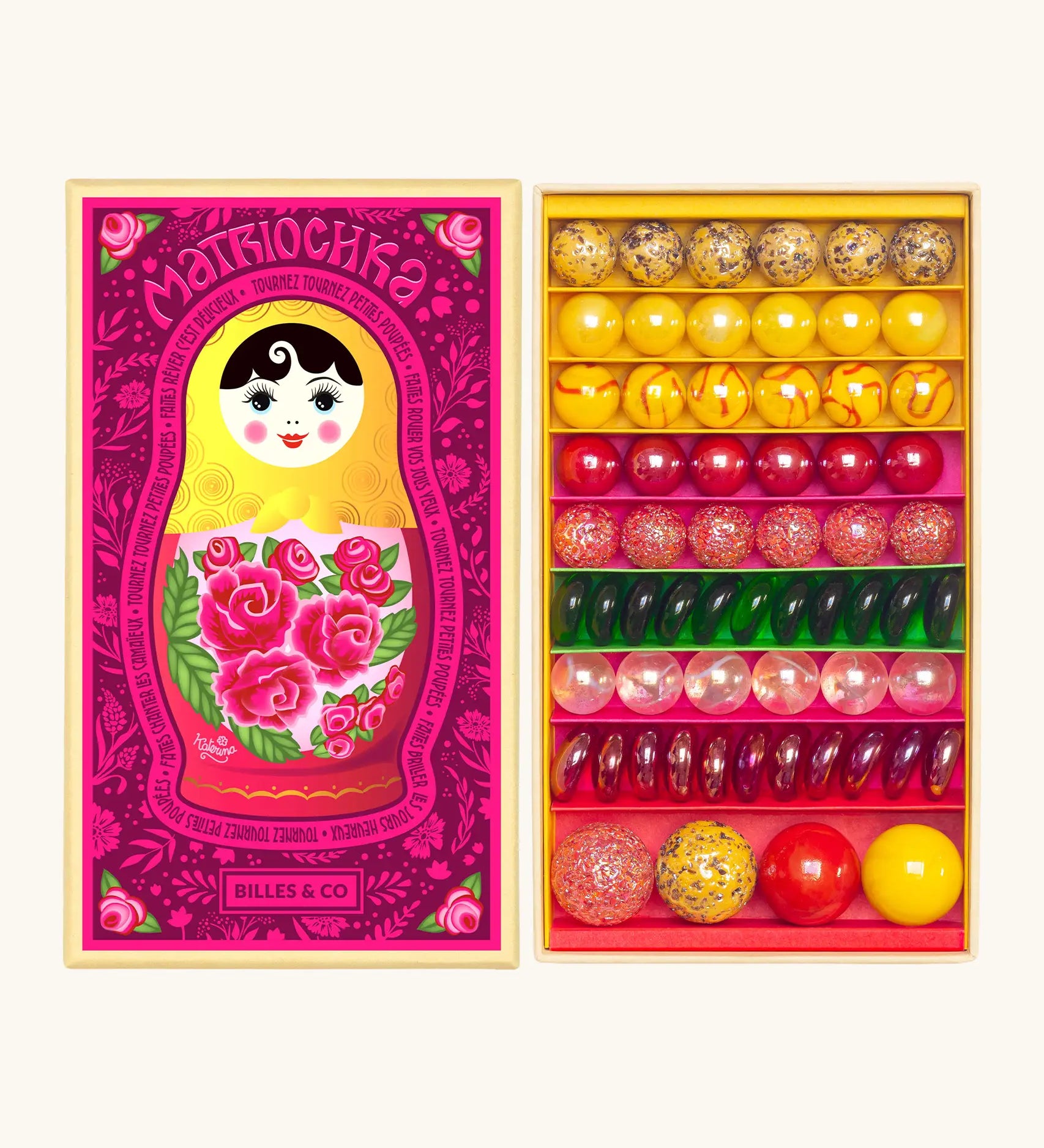 Opened decorated box of Billes & Co Katerina Matriochka doll inspired marbles in shades of pink, green and yellow