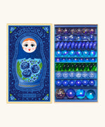 Opened decorated box of Billes & Co Yelena Matriochka doll inspired marbles in shades of blues and greens