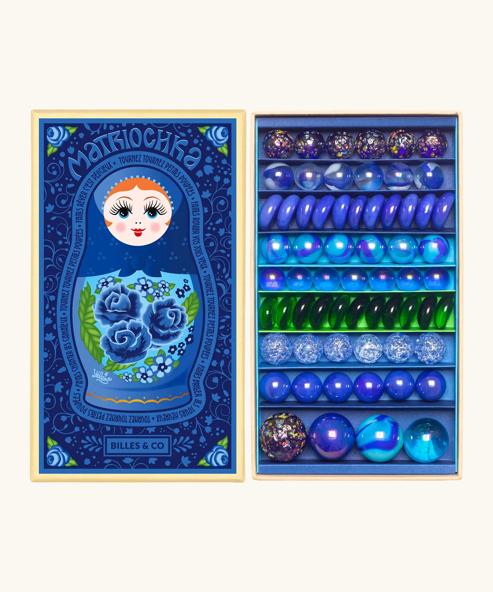 Opened decorated box of Billes & Co Yelena Matriochka doll inspired marbles in shades of blues and greens