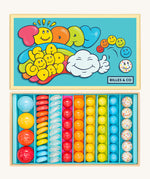 Billes & Co marbles in today's a good day inspired set. Features 67 rainbow coloured  glass marbles with a mixture of textured and flat marbles. Comes in a bright blue coloured box with a playful design of a cloud and rainbow. 