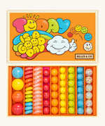 Billes & Co marbles in today's a good day inspired set. Features 67 rainbow coloured  glass marbles with a mixture of textured and flat marbles. Comes in a orange coloured box with a playful design of a cloud and rainbow. 
