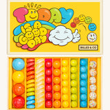 Billes & Co marbles in today's a good day inspired set. Features 67 rainbow coloured  glass marbles with a mixture of textured and flat marbles. Comes in a yellow coloured box with a playful design of a cloud and rainbow. 