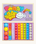 Billes & Co marbles in today's a good day inspired set. Features 67 rainbow coloured  glass marbles with a mixture of textured and flat marbles. Comes in a lilac coloured box with a playful design of a cloud and rainbow. 
