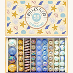 Billes & Co Seashells Glass Marbles Box - 58 Pack. Includes flat, large and small marbles which are smooth and some are textured with a seashell and beach design and colour