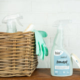 A bottle of Bio-D limescale remover standing on a wooden surface next to a wooden cleaning basket. This limescale remover is available at Babipur. 
