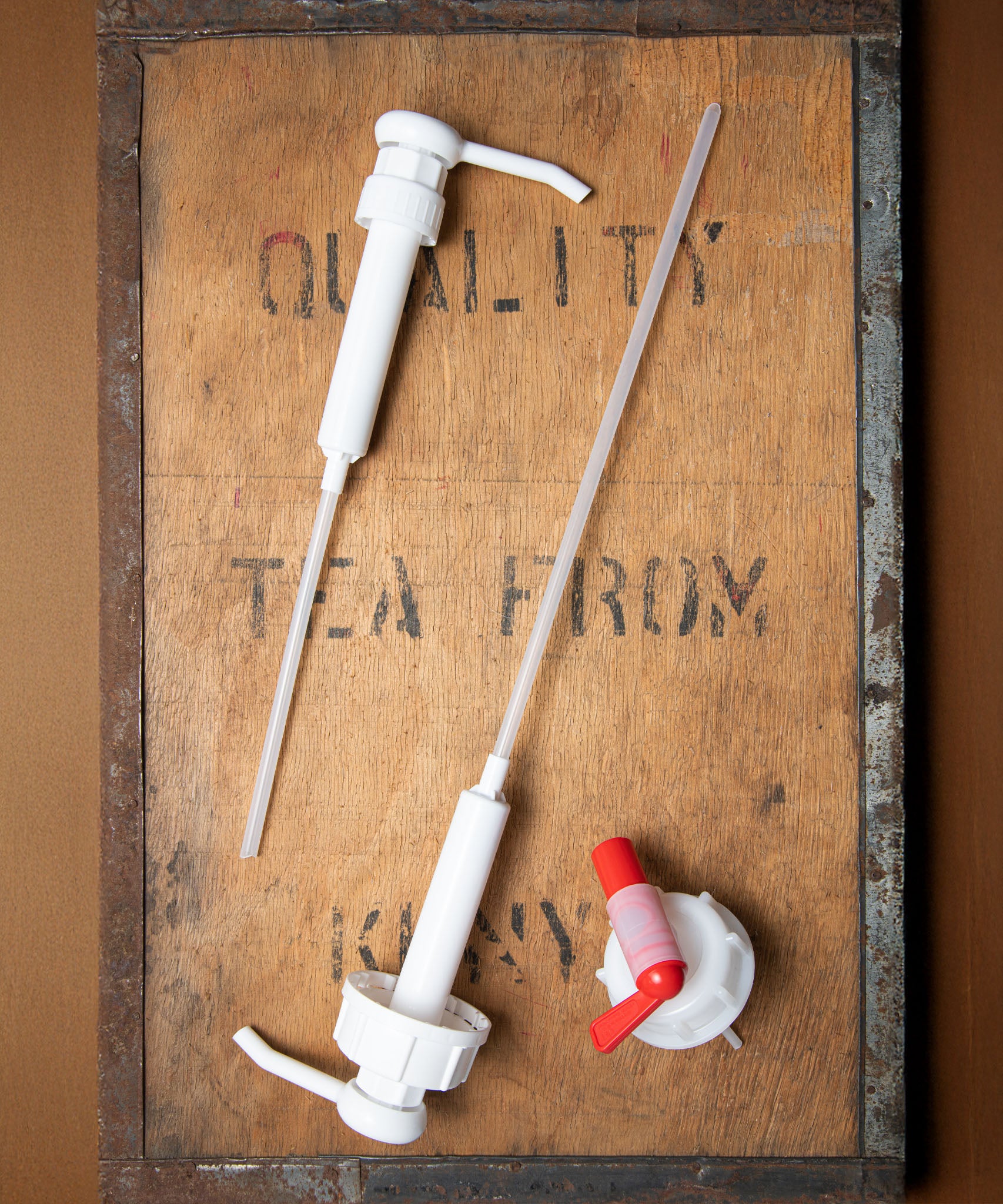 A Bio-D 5L screw on pump lying next to a 20L pump and tap adapter both available at Babipur. These pumpscan be used on any 5L and 20L Bio-D liquid for easy refilling 