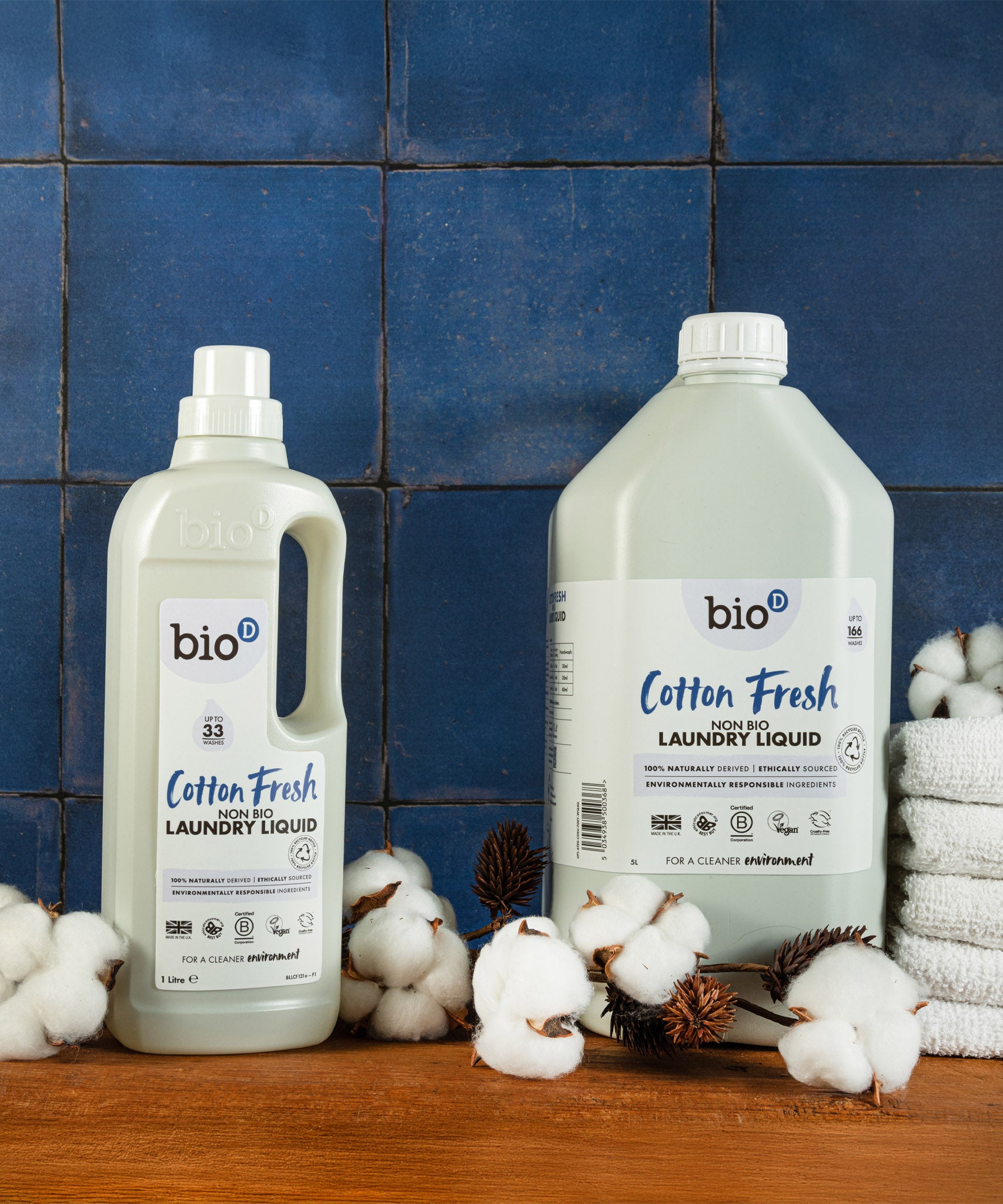A 5L bottle of Bio-D cotton fresh non bio laundry liquid standing next to a 1L bottle and sprigs of cotton. Both sizes are available at Babipur.