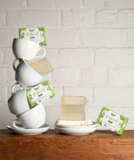 A stack of white mugs with bars of the Bio-D dish washing soap inside them. These dish soap bars are available at Babipur.