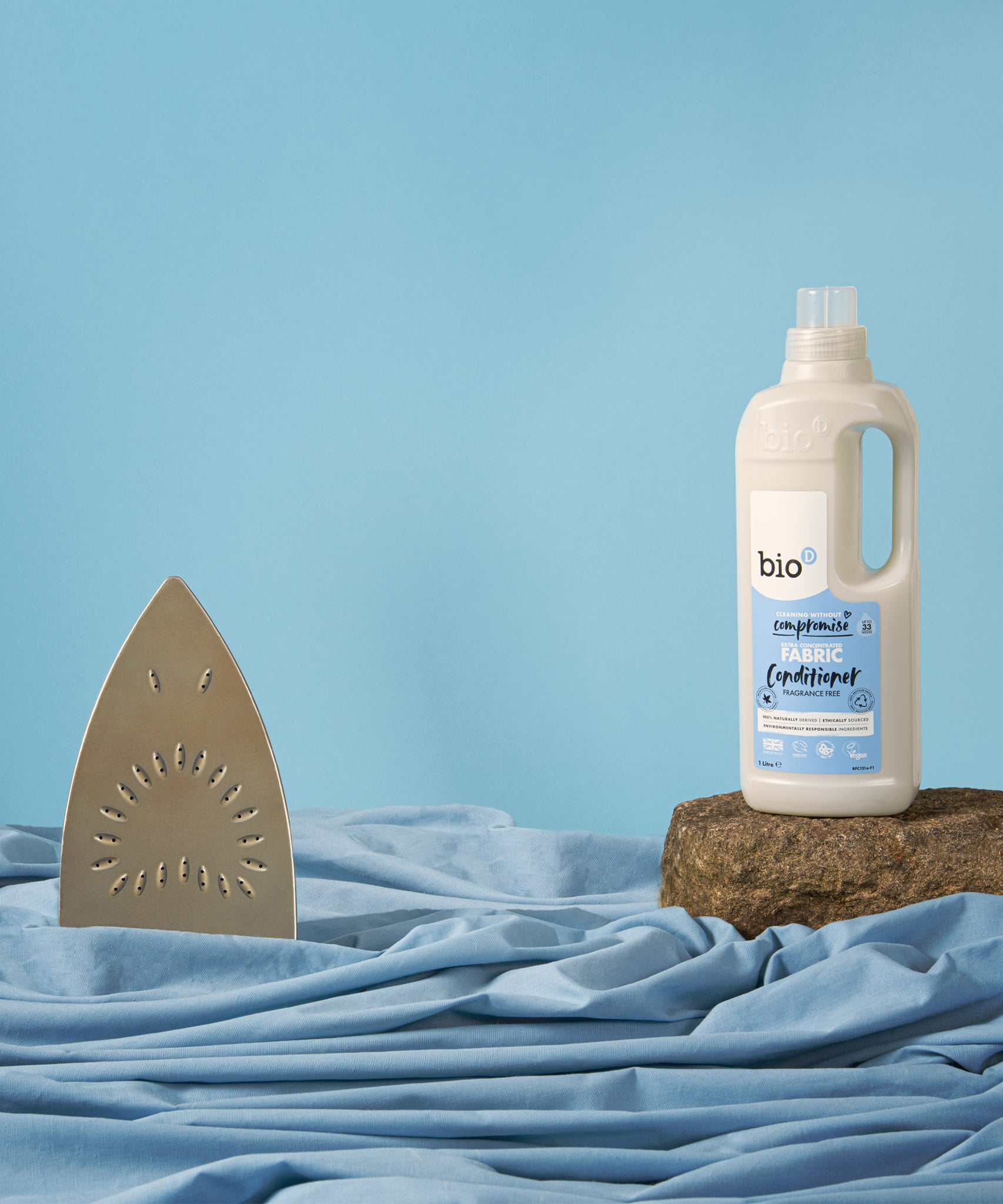 A 1L bottle of Bio-D fragrance free fabric conditioner standing on top of a rock with next to iron. This fabric conditioner is available at Babipur. 