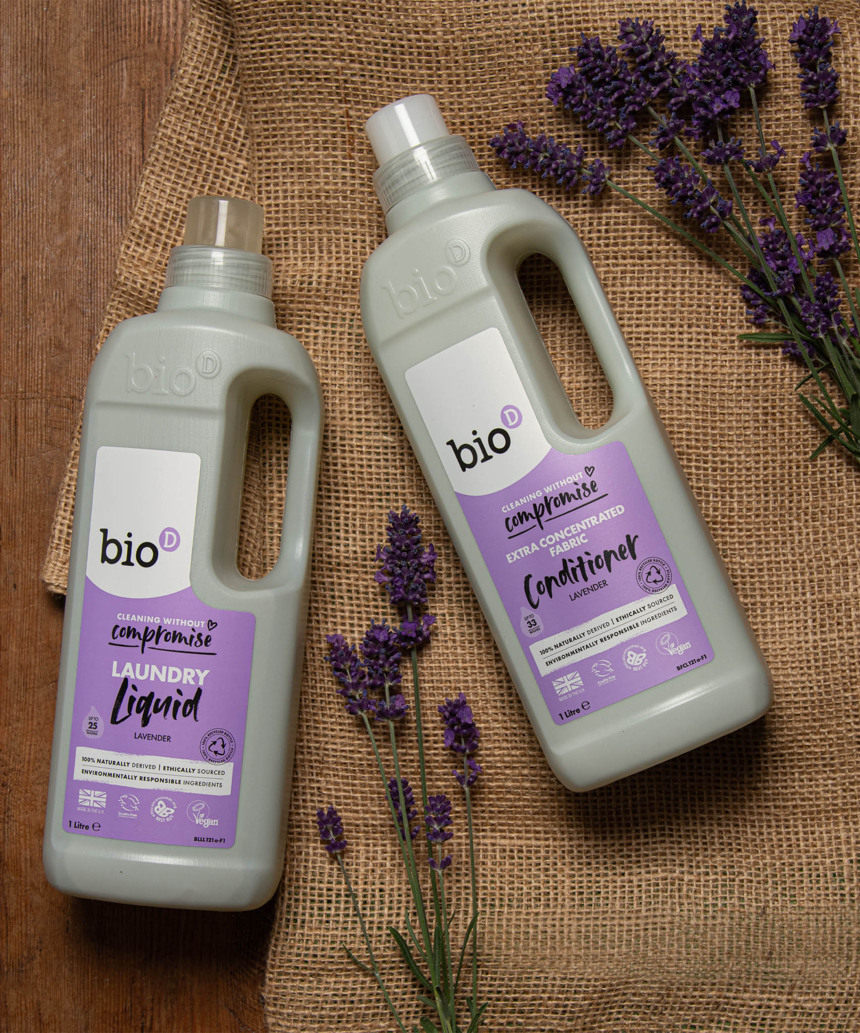 A 1L bottle of Bio-D lavender fabric conditioner and laundry liquid on a piece of hessian with sprigs of lavender on top. Both are available at Babipur. 