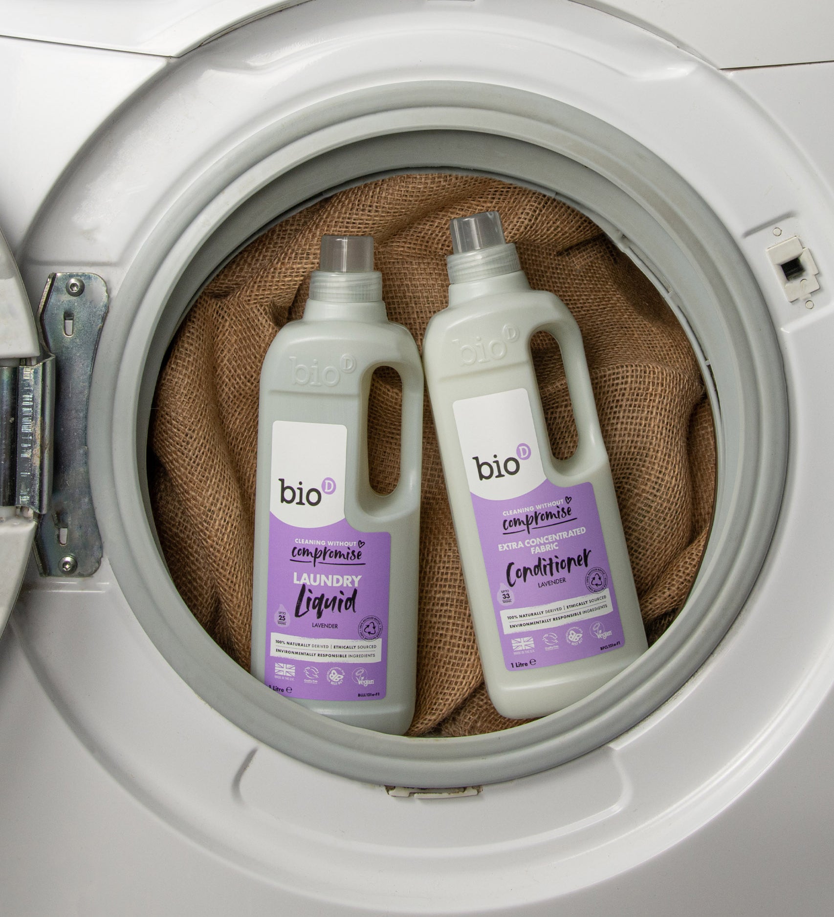 A 1L bottle of Bio-D lavender fabric conditioner and laundry liquid inside a washing machine. Both are available at Babipur. 