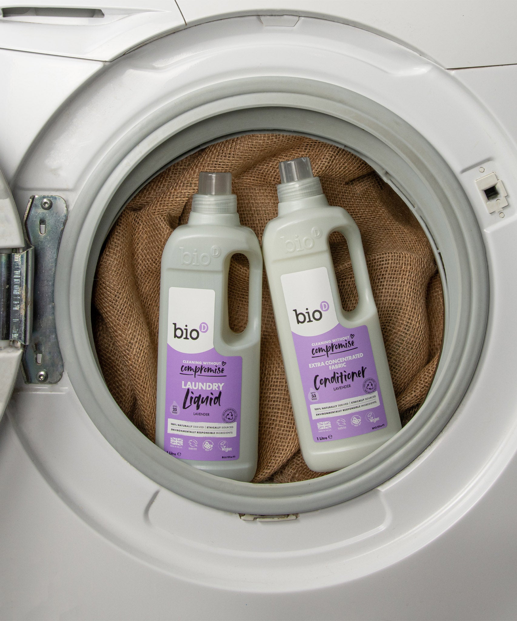 A 1L bottle of Bio-D lavender fabric conditioner and laundry liquid inside a washing machine. Both are available at Babipur. 