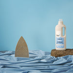 Bio-D fragrance free fabric conditioner 1 litre bottle on a blue back ground with a pretend iron shark in blue fabric water