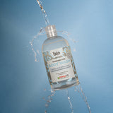 Bio-D fragrance free body wash bottle photographed mid air with water pouring and splashing through the open cap.