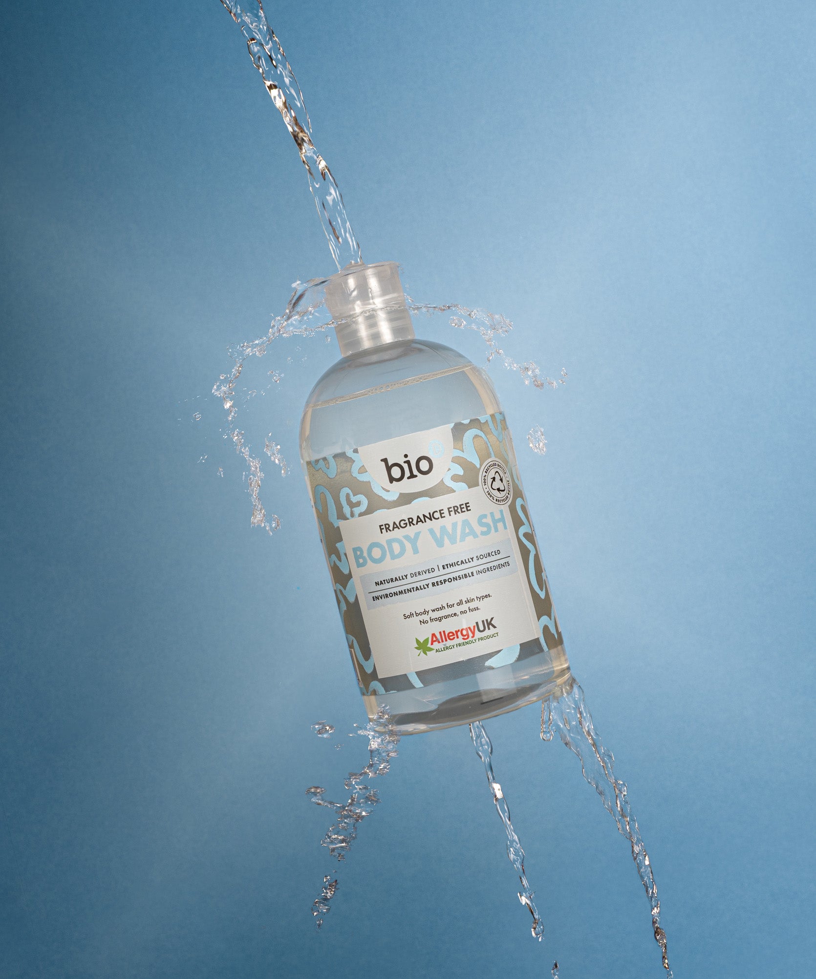 Bio-D fragrance free body wash bottle photographed mid air with water pouring and splashing through the open cap.