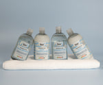Bio-D fragrance-free shampoo and hair conditioner bottles arranged on a folded towel, showing Allergy UK approved hair care for sensitive scalps and fragrance-sensitive households.
