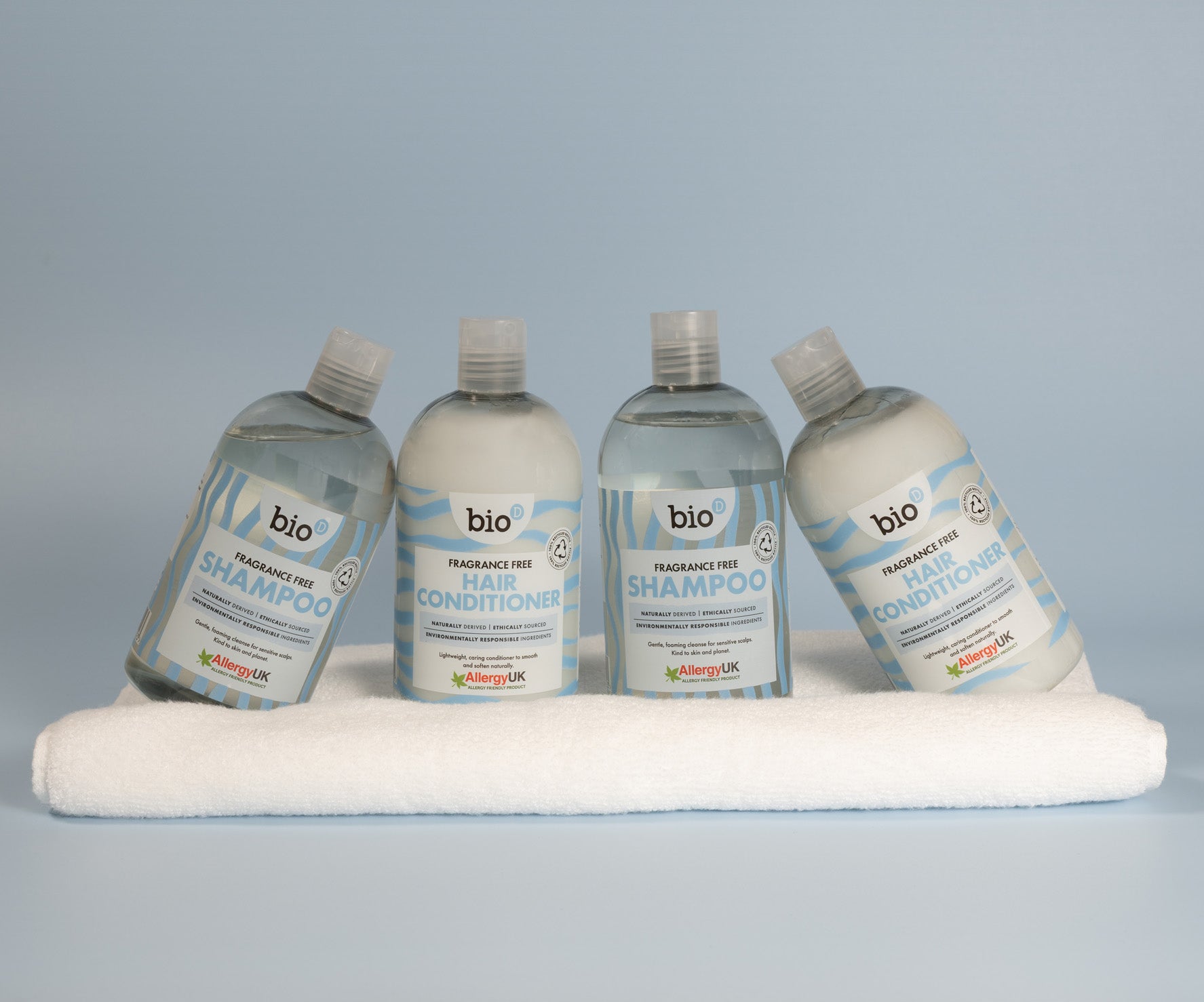 Bio-D fragrance-free shampoo and hair conditioner bottles arranged on a folded towel, showing Allergy UK approved hair care for sensitive scalps and fragrance-sensitive households.