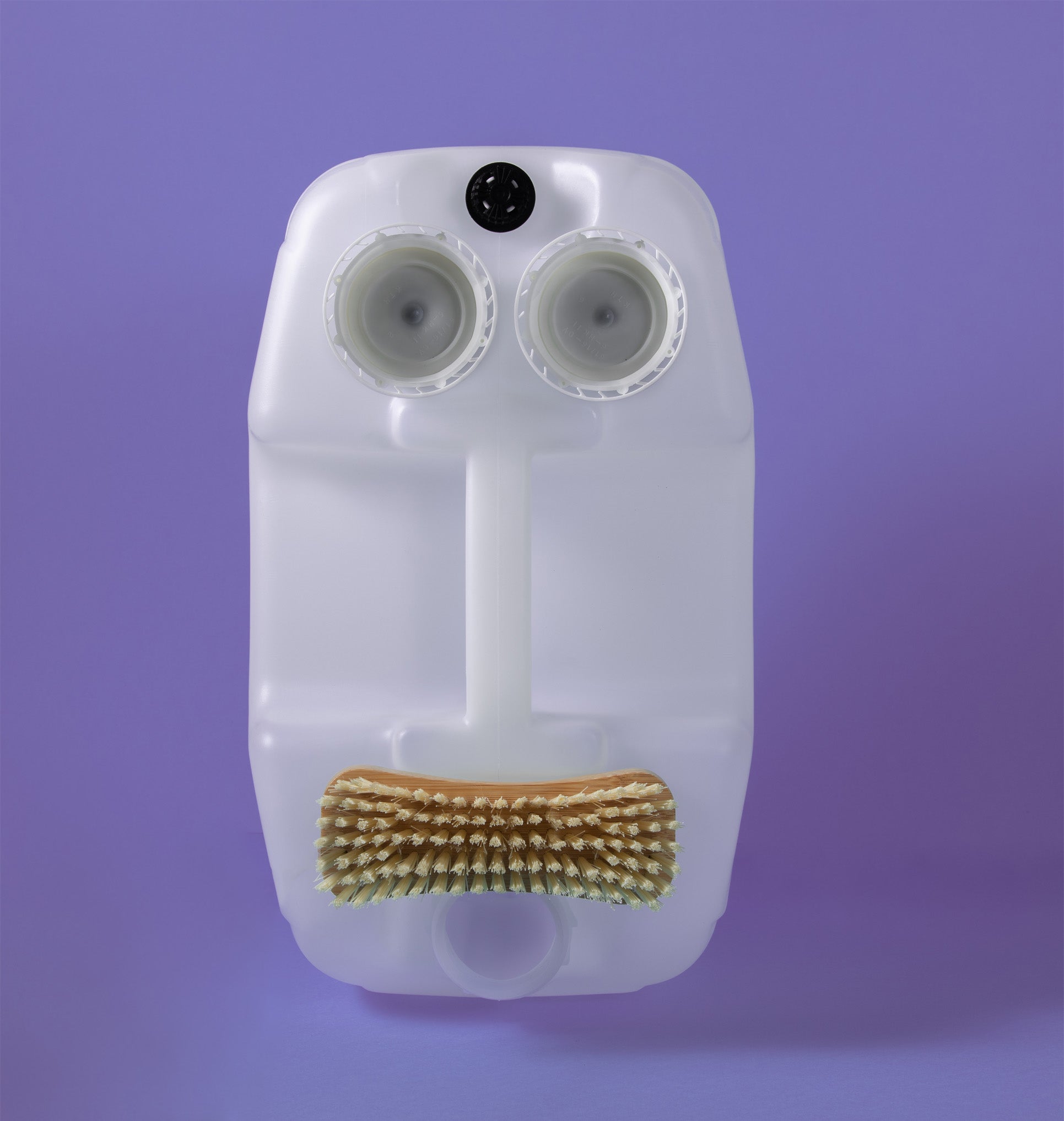 A reused Bio-D 5 litre washing up liquid container with upcycled lids and a dish brush arranged as a playful face, highlighting the brand’s refill and reuse ethos promoted by Babipur.