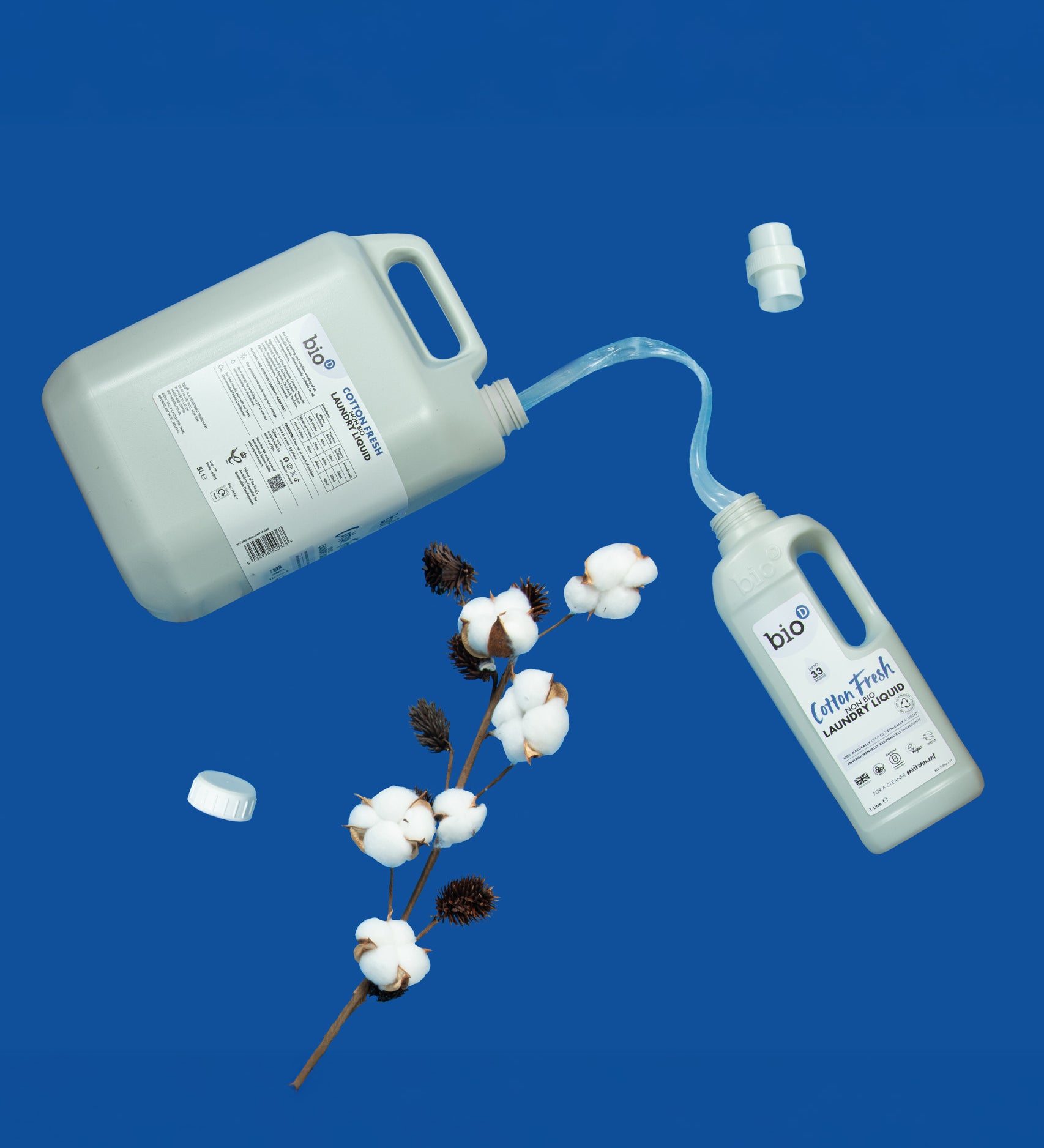 A 5L bottle of Bio-D cotton fresh non bio laundry liquid pouring into a 1L bottle. These two bottles are available at Babipur.