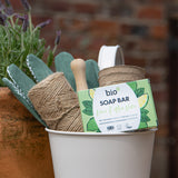 A Bio-D lime & aloe vera soap bar inside a bucket with various gardening items. This soap bar is available at Babipur