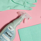 A bottle of Bio-D limescale remover lying flat on a pink background next to light green cleaning products. This limescale remover is available at Babipur. 
