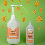 A Bio-D 5L mandarin washing up liquid being poured into a 750ml bottle. Both bottles are available at Babipur 