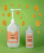 A Bio-D 5L mandarin washing up liquid being poured into a 750ml bottle. Both bottles are available at Babipur 