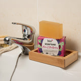 Bio-D plum & mulberry soap bar standing in a wooden soap dish on a sink. This soap bar is available at Babipur.