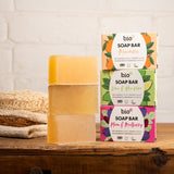 A stack of the 3 different Bio-D soap bars on a wooden surface. These soap bars are available at Babipur
