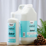 Front view of Bio-D Home and Garden Cleaner bottles in 750ml and 5 litre sizes, standing on a wooden surface with pine cones and greenery to show the refill size alongside the smaller bottle.