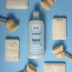 Bio-D Fragrance Free natural vegan friendly Washing Up Liquid in a 750ml bottle pictured on a blue back ground with wooden dish brushes and natural sponges