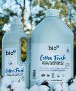 A 1 and 5L bottle of Bio-D cotton fresh fabric conditioner standing on a pile of cotton.