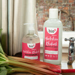 A 500ml bottle of Bio-D hand wash and washing up liquid up in Yorkshire rhubarb on a wooden sink next to a bunch of rhubarb