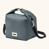 Side of Black+Blum 10 litres insulated and water repellent roll top lunch bag in slate blue showing carry strap hooked on the side loop