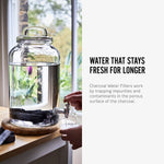 An info graphic featuring an image and text about the Black+Blum Active Charcoal Water Filter. The image shows the charcoal filters in a large glass water dispenser. The text reads, Water that stays fresh for longer. Charcoal water filters work by trapping impurities and contaminants in the porous surface of the charcoal.