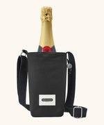 Black + Blum insulated water repellent bottle bag in black with the lid open showing a bottle of champagne sitting inside 