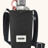 Black + Blum insulated water repellent bottle bag in black with the lid open showing a flask sitting inside 