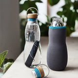 Black + Blum glass bottle with active charcoal water filter and locking coil showing the felted holder and lid detail.
