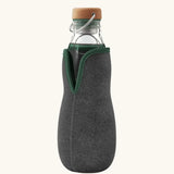 Black + Blum glass bottle with active charcoal water filter and locking coil . Features a felted holder with olive green trim and a cork lid with a loop handle.
